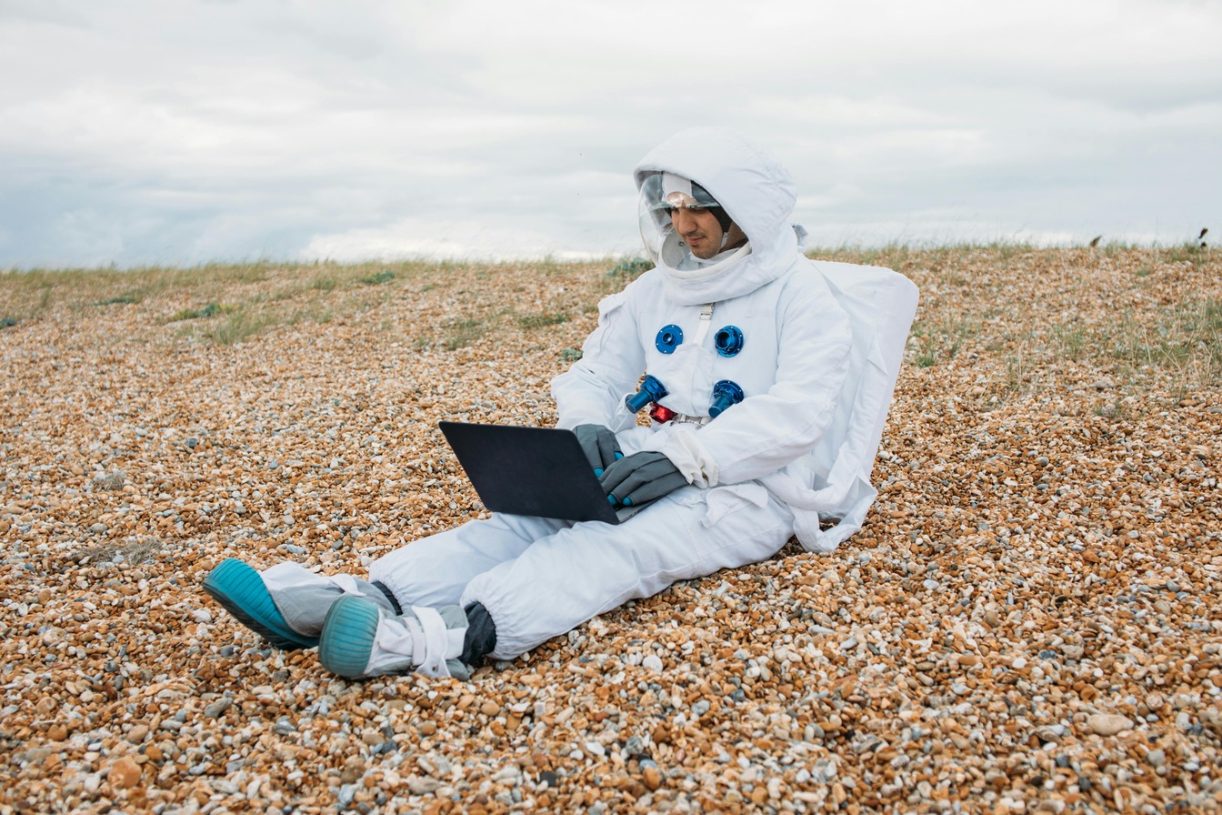 astronaut sitting with computer on his lap